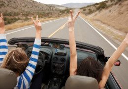 Hands up, while driving a convertible.